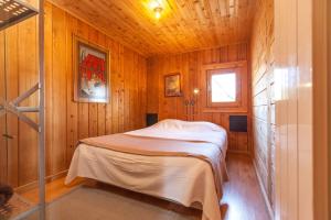 a bedroom with a bed in a wooden room at Casa da Piscina - Casas de Alem - Ecoturismo in Arcos de Valdevez