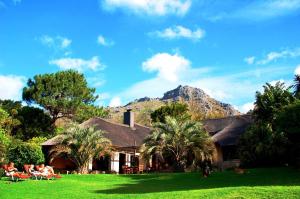 a house with a mountain in the background at Thulani River Lodge in Hout Bay