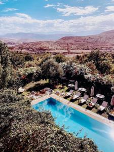 uma vista aérea para uma piscina com cadeiras e guarda-sóis em Les terrasses du Lac Marrakech em Lalla Takerkoust