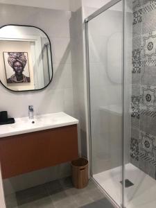 een badkamer met een douche, een wastafel en een spiegel bij Le terrazze 11 in Puerto de la Cruz