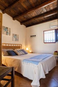 a bedroom with a large bed in a room with wooden ceilings at Dammusi Ziunì in Lampedusa