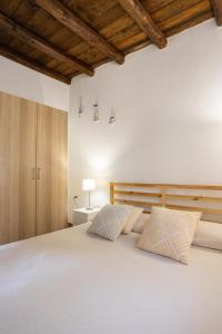 a bedroom with a large white bed with two pillows at Dammusi Ziunì in Lampedusa