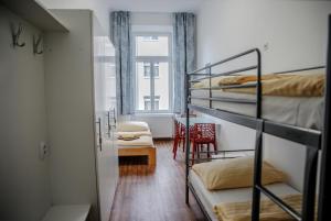 a room with three bunk beds and a window at Cuba Bar & Hostel in České Budějovice