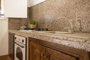 a kitchen counter with a sink and a stove at Dammusi Ziunì in Lampedusa