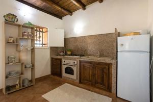 a kitchen with a white refrigerator and a stove at Dammusi Ziunì in Lampedusa