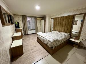 伊斯坦堡的住宿－CAMELLİA SUİT HOTEL，一间卧室配有一张带木制床头板的床