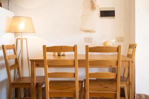 a dining room with a table and chairs and a lamp at Dammusi Ziunì in Lampedusa