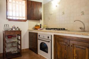 a kitchen with a stove top oven next to a sink at Dammusi Ziunì in Lampedusa