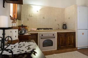 a kitchen with a stove and a white refrigerator at Dammusi Ziunì in Lampedusa