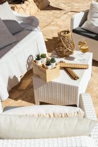 a rattan coffee table with potted plants on it at Dammusi Ziunì in Lampedusa