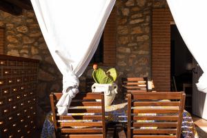 a table with chairs and a vase with a plant at Dammusi Ziunì in Lampedusa