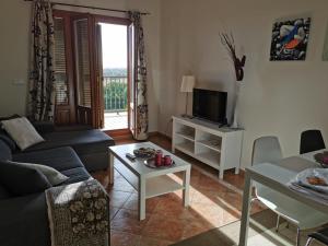 sala de estar con sofá y TV en Finim Solis Apartamentos, en Ayamonte
