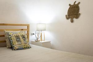 a bedroom with a bed with a pillow and a lamp at Dammusi Ziunì in Lampedusa