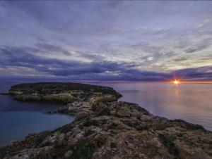 a small island in the water at dusk at Dammusi Ziunì in Lampedusa