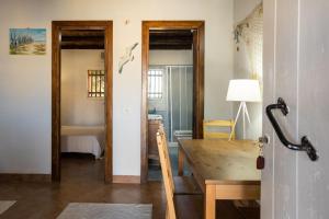 a dining room with a table and a room with a sink at Dammusi Ziunì in Lampedusa