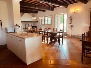 モンテプルチャーノにあるTenuta Golo Luxury Villa - Wine Estate with Pool near Montepulcianoのテーブルと椅子のあるキッチンとダイニングルーム