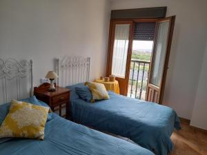 sypialnia z dwoma łóżkami i balkonem w obiekcie Finim Solis Apartamentos w mieście Ayamonte