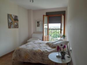 Un dormitorio con una cama y una mesa con flores. en Finim Solis Apartamentos, en Ayamonte