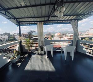 a balcony with white chairs and a view of a city at SunsetHomes A luxurious studio apartment in Imphal