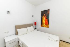 una camera con un letto bianco e un dipinto sul muro di Duplex House with Shared Pool near Beach in Kalkan a Kalkan