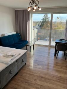 1 dormitorio con sofá azul y ventana grande en JAB Apartament Przy Klinice Business & Family en Szczecin