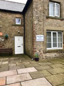 a brick building with a white door and a sign on it at Last Cottage in Richmond