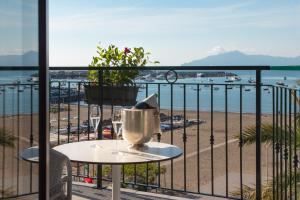 a table on a balcony with a view of the beach at Miramare Suites in Sestri Levante