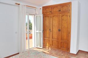 コニル・デ・ラ・フロンテーラにあるChalet Pradilloの大きな木製キャビネットとドアが備わる客室です。
