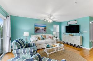 a living room with a couch and a tv at South Beach Views in Tybee Island