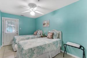 a bedroom with two beds and a ceiling fan at South Beach Views in Tybee Island