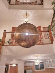 a large gold orb hanging from the ceiling of a room at Riad with 3 Swimming Pools in Marrakech