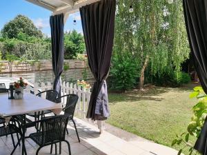 patio ze stołem i krzesłami na podwórku w obiekcie Holiday Home Balatonszárszó w mieście Balatonszárszó