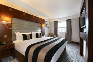 a hotel room with two beds and two lamps at Park Grand London Kensington in London