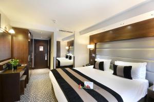 a hotel room with a large bed and a bathroom at Park Grand London Kensington in London