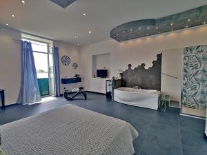 um quarto com uma cama e uma banheira num quarto em Borgo Blu em Bacoli