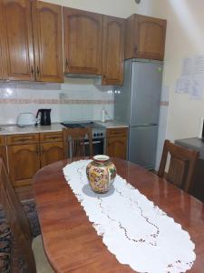 a kitchen with a wooden table with a vase on it at Apartman Dane in Kikinda