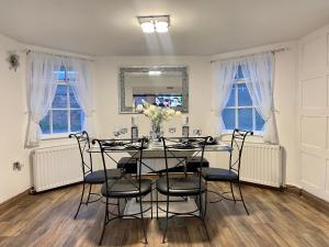 a dining room with a table and chairs at Tollgate House - Luxury Cozy Cottage - HUGE Hot Tub - Alton Towers in Cheadle