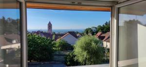 una ventana con vistas a la ciudad en Au toit de l’Alsace - Loft au pied des Vosges, en Wattwiller