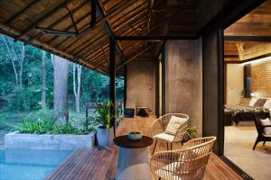 a house with a pool and chairs and a table at Kaav Safari Lodge, Kabini in Begūr