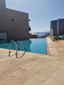 une piscine sur le côté d'un immeuble dans l'établissement Spacious and comfortable Paraiso II, à Playa Paraiso