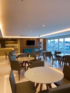 a restaurant with tables and chairs and windows at Fortaleza Sul Flats Service in Fortaleza