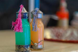 due bottiglie colorate sedute sopra un tavolo di Zahra Luxury Desert Camp a Merzouga
