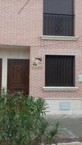 a brick building with a door and a sign on it at LA QUEDADA DE NAVA in Nava del Rey