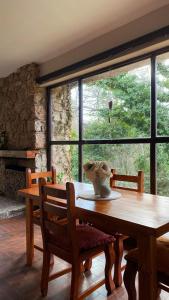 a dining room with a wooden table and a large window at El gran roble in La Cumbrecita