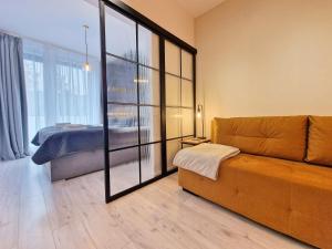 uma sala de estar com um sofá e um quarto em Apartament MODERN 64 Z Widokiem Na Morze - 365PAM em Ustronie Morskie