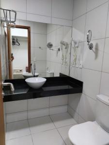 a white bathroom with a sink and a toilet at Iloa Prime 103 V in Barra de São Miguel