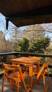 a wooden table and two chairs on a deck at El gran roble in La Cumbrecita