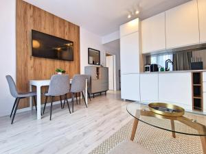 隱海市的住宿－Apartament MODERN 64 Z Widokiem Na Morze - 365PAM，厨房以及带桌椅的起居室。