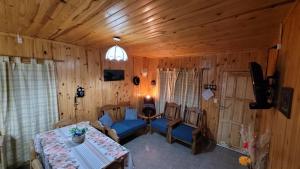 sala de estar con sofá azul y mesa en Cabañas de Montaña Tecta-Cher en Potrerillos