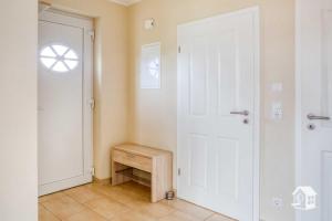 a hallway with a white door and a window at Appartement Sundevit in Börgerende-Rethwisch